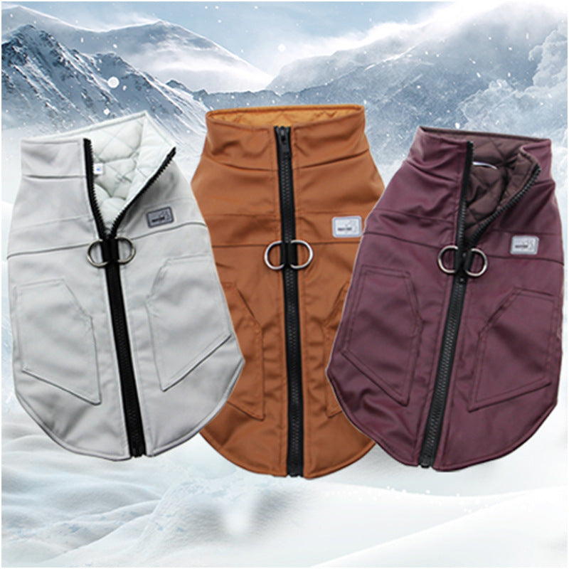Three dog coats in white, brown, and purple on a snowy mountain background