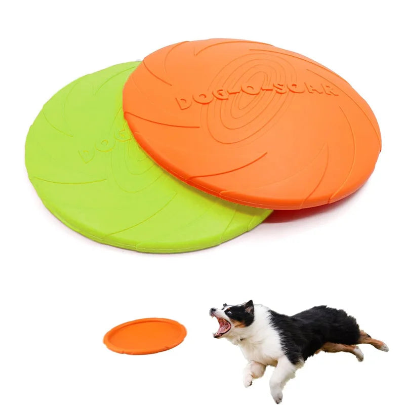 Two orange and green dog frisbees with a dog in the background on a white background