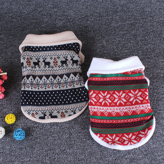 Two patterned dog sweaters on a textured surface with colorful balls.