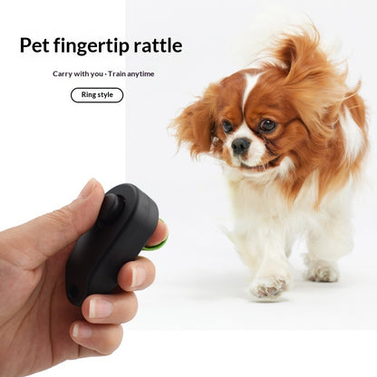 Pet fingertip rattle with a hand holding it and a dog in the background